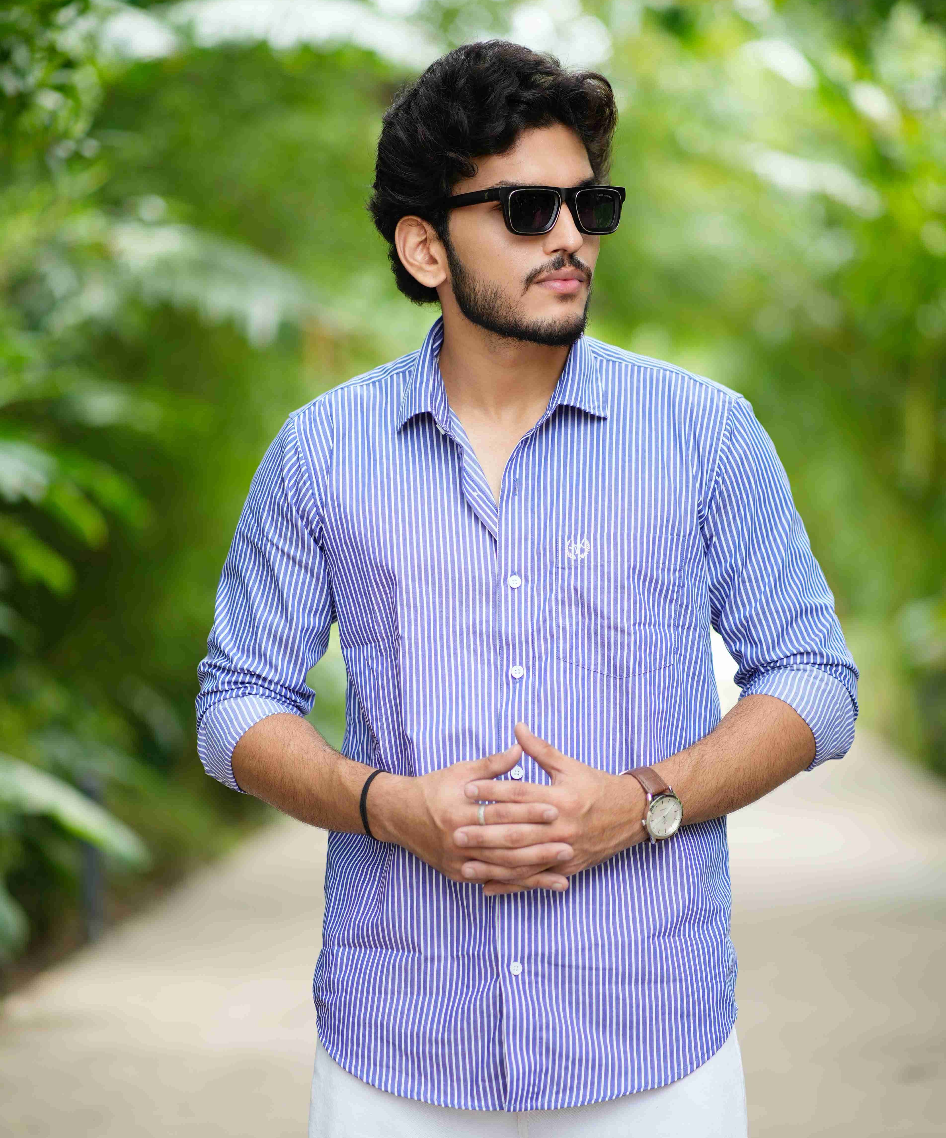 formal_shirt_-_Amerald_arrows Man wearing a blue checkered shirt and sunglasses in a forest setting