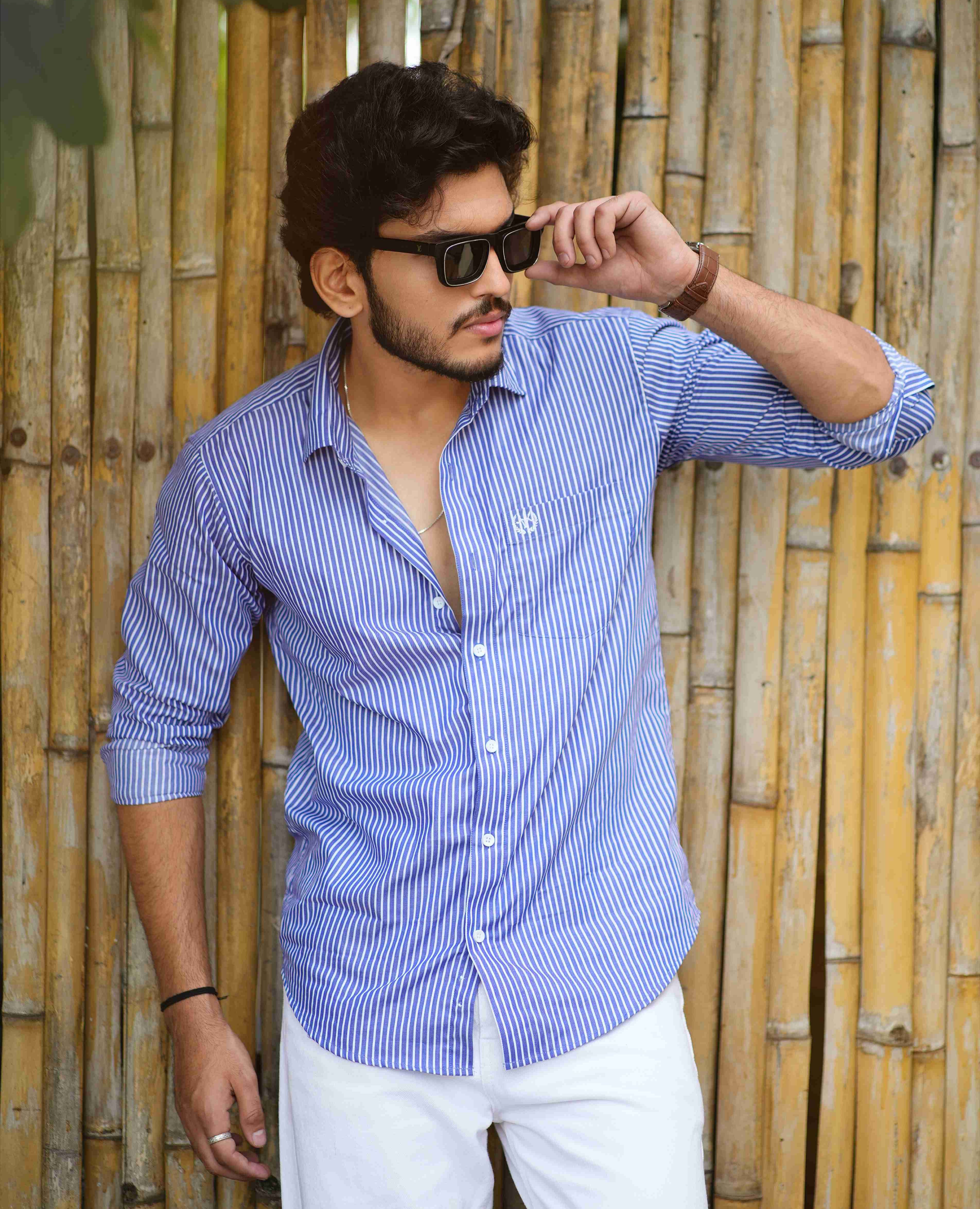 formal_shirt_-_Amerald_arrows Man wearing a blue striped shirt and sunglasses against a bamboo wall