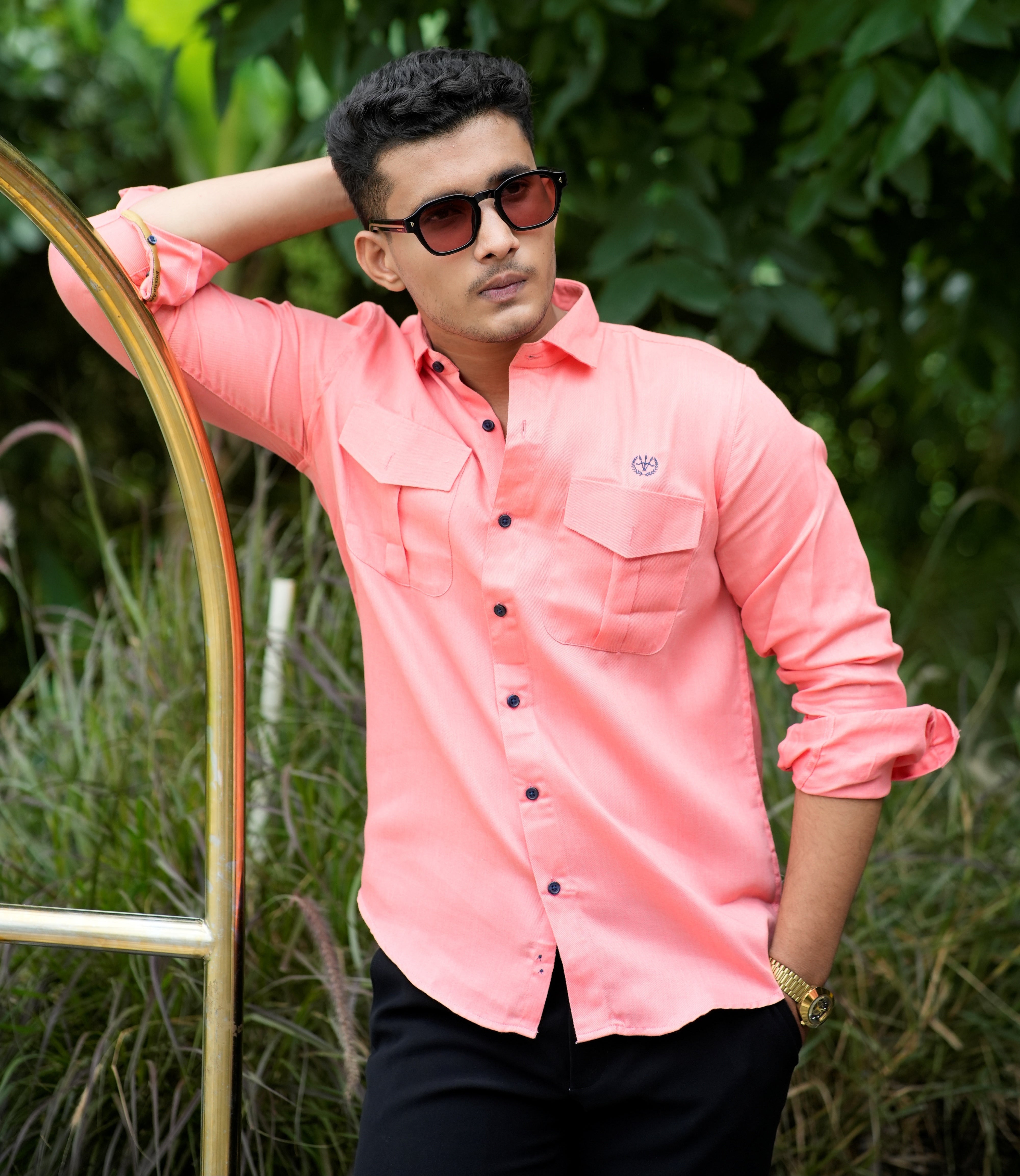 Person wearing a pink shirt and sunglasses in a natural setting
